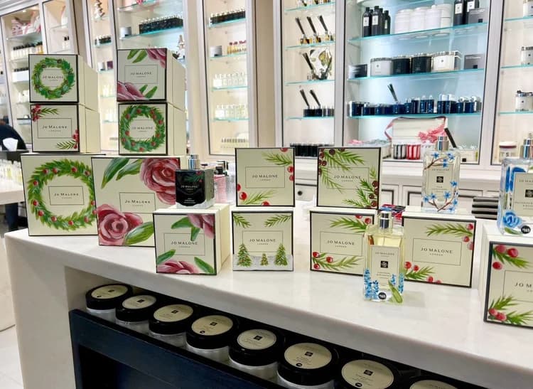 An artist's table with gift boxes and a freshly personalized fragrance bottle.